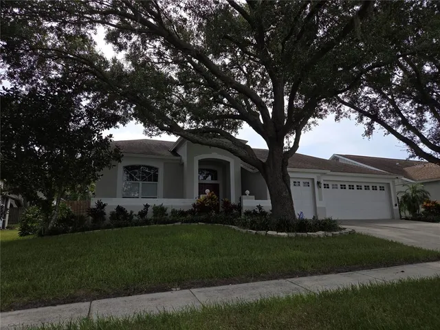 a front view of a house with a garden and trees