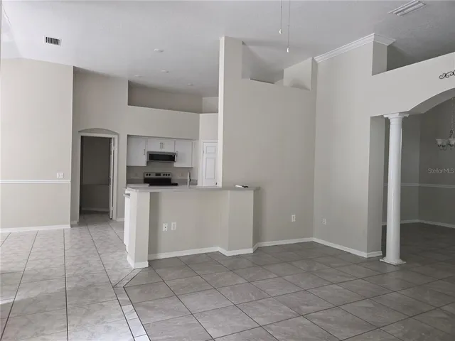 a kitchen with a refrigerator and white cabinets