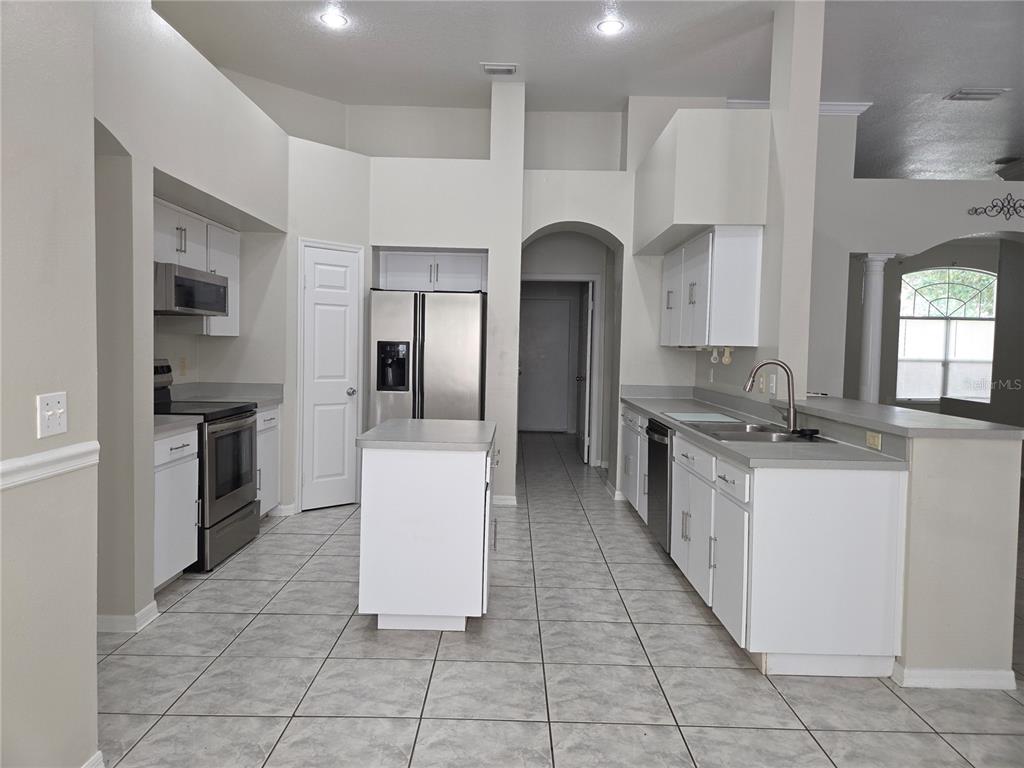 4511 Oak River Circle Valrico, FL 33596 - Photo 6 of 14 a large kitchen with stainless steel appliances a refrigerator and a stove top oven