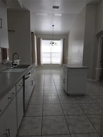 a kitchen with a sink a window and cabinets