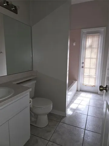 a bathroom with a toilet a window and a shower