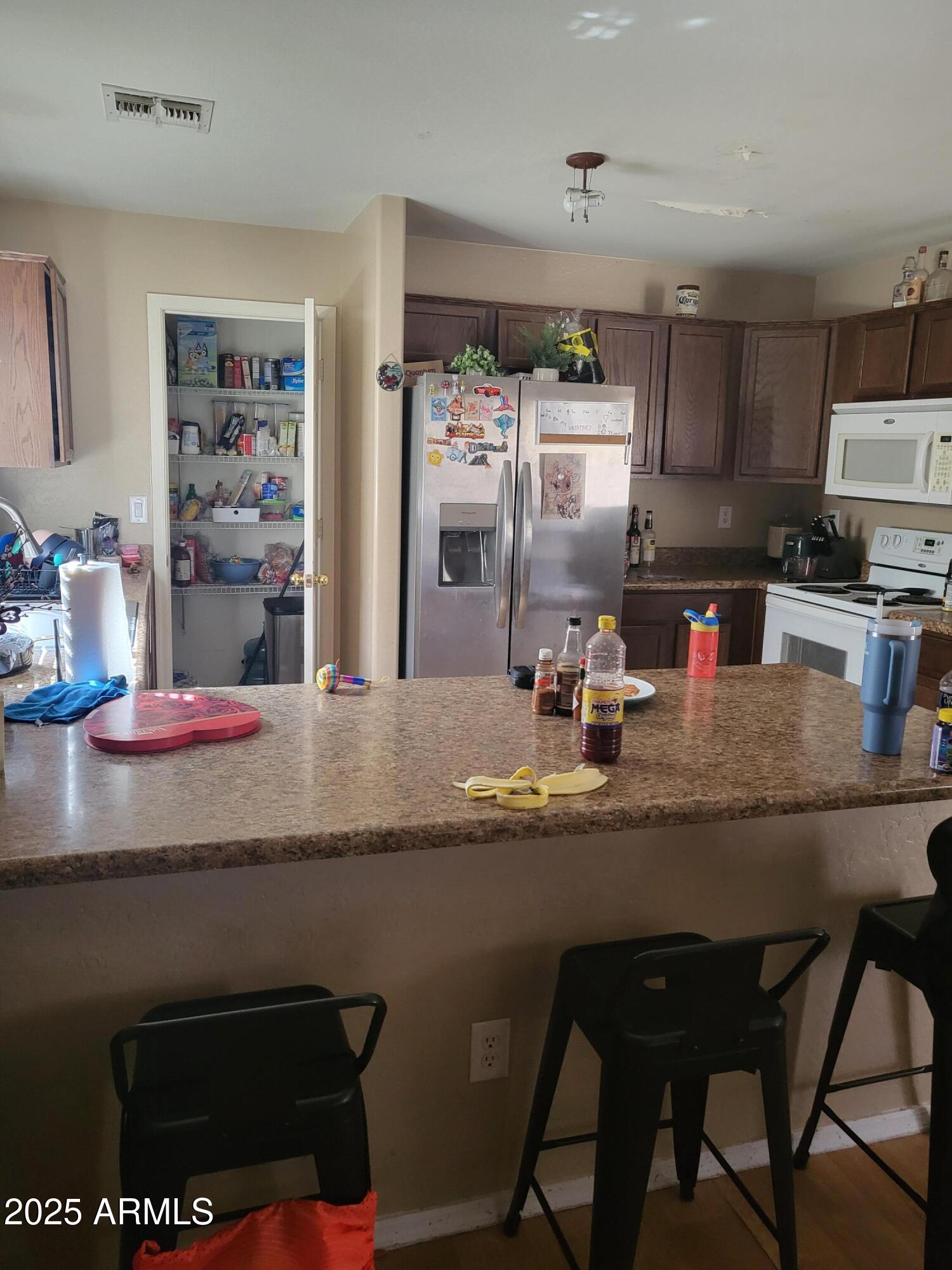 43718 West Magnolia Road Maricopa, AZ 85138 - Photo 10 of 21 a kitchen with kitchen island granite countertop a sink cabinets and stainless steel appliances