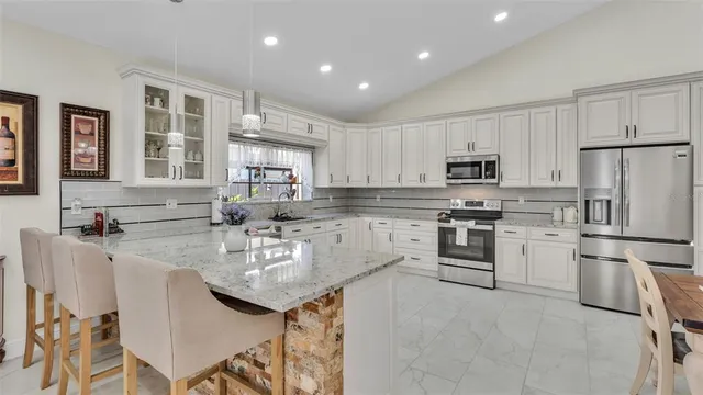 a kitchen with stainless steel appliances granite countertop a sink and a refrigerator