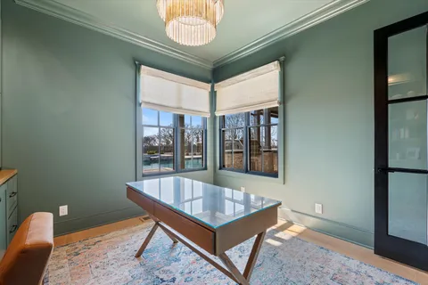 a bedroom with a bed a dresser and a chandelier