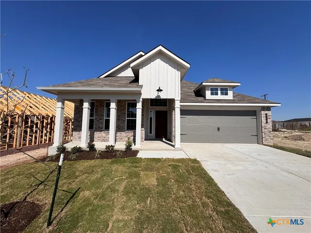 a front view of a house with yard and porch