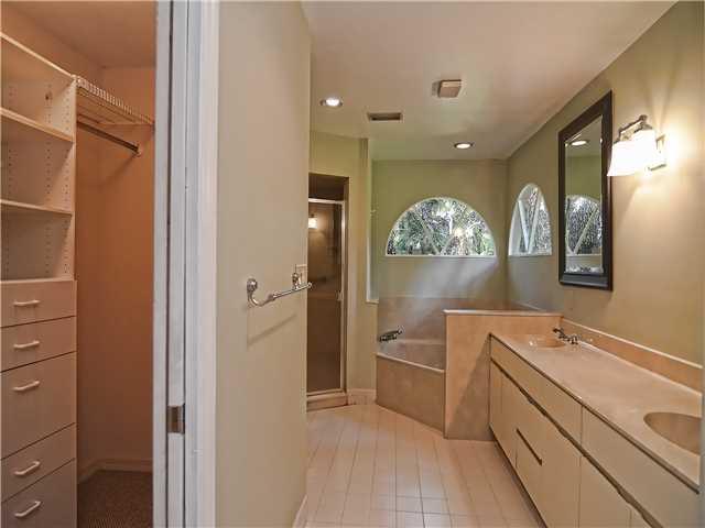 13 Palm Road Sewall's Point, FL 34996 - Photo 19 of 25 a spacious bathroom with a double vanity sink a large mirror a shower and a bathtub