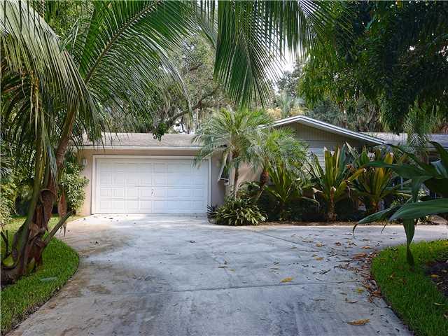 13 Palm Road Sewall's Point, FL 34996 - Photo 5 of 25 a front view of a house with a yard and a garage