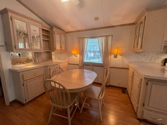a kitchen that has a table chairs in it and wooden floors