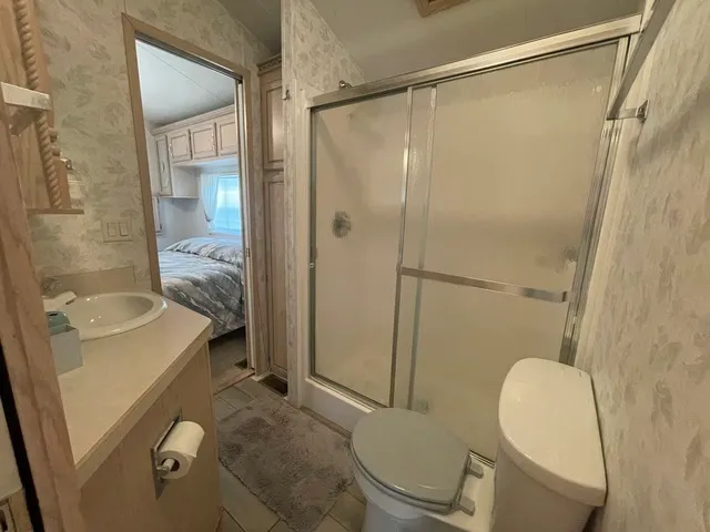 a bathroom with a granite countertop sink toilet and shower