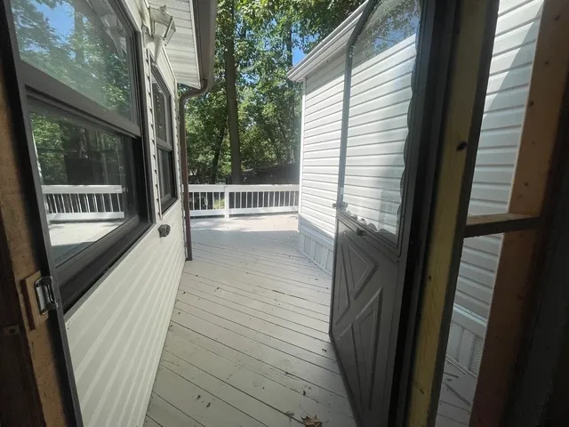 a view of a balcony with wooden floor and fence