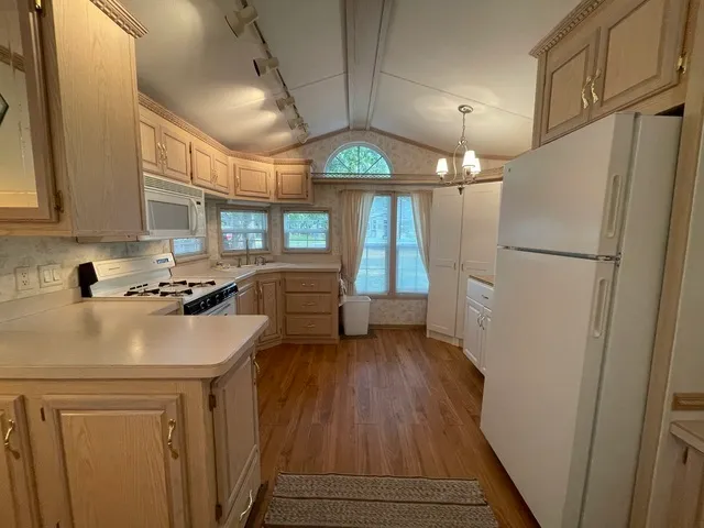 a kitchen with a refrigerator a stove a sink and a window