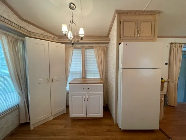 a view of a kitchen with a refrigerator wooden floor and door