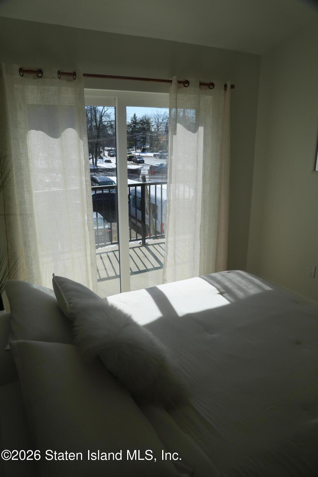 1239 Forest Hill Road, Unit 24 Staten Island, NY 10314 - Photo 6 of 8 a bedroom with a bed and glass door