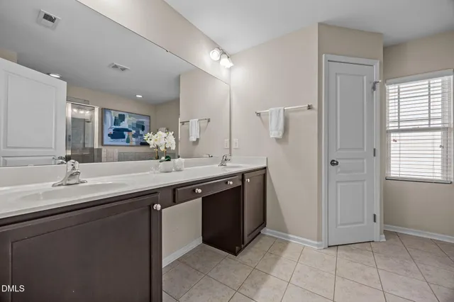 a spacious bathroom with a double vanity sink and mirror