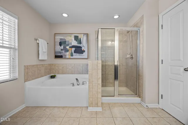 a bathroom with a tub shower and window