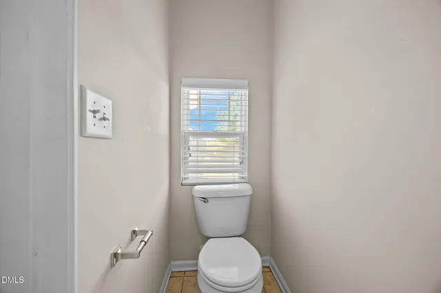 a white toilet sitting next to a small window