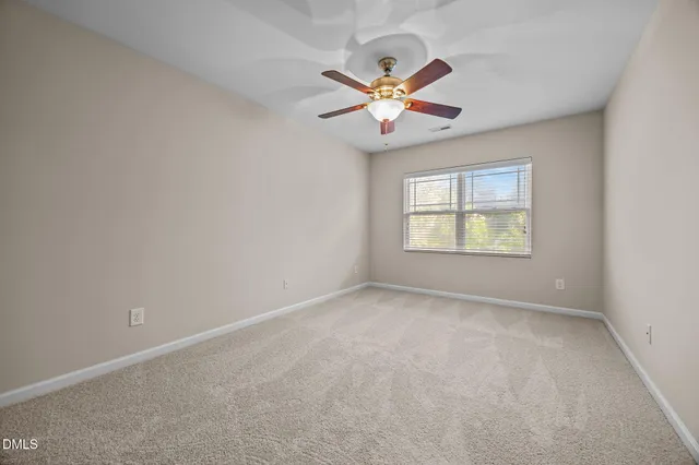 an empty room with a window and a fan