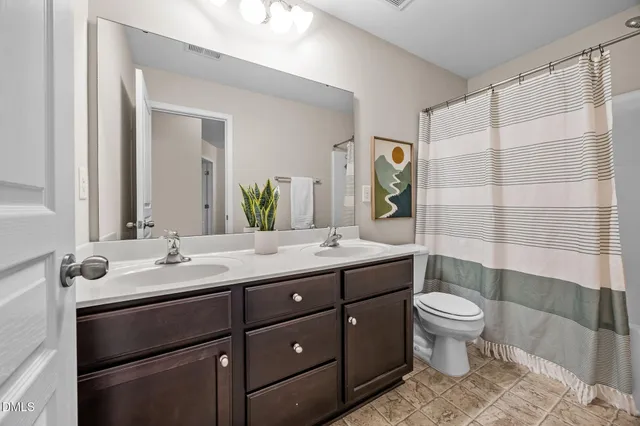 a bathroom with a double vanity sink toilet and shower