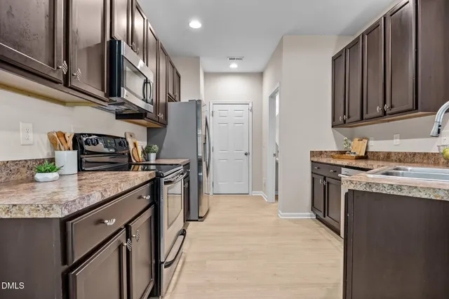a kitchen with stainless steel appliances granite countertop a sink stove and refrigerator