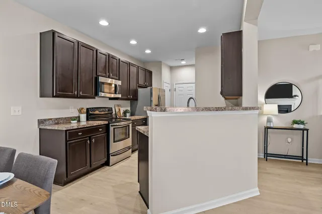 a kitchen with kitchen island granite countertop wooden cabinets a stove top oven a sink and dishwasher