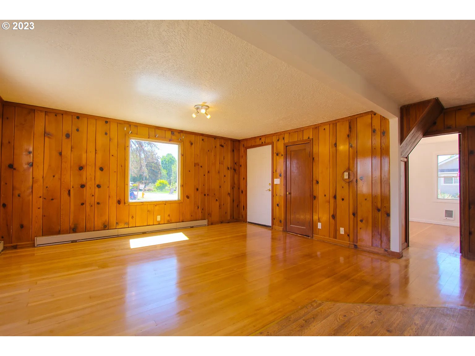 711 Southeast 5th Street Gresham, OR 97080 - Photo 3 of 25 a view of an empty room with wooden floor and a window