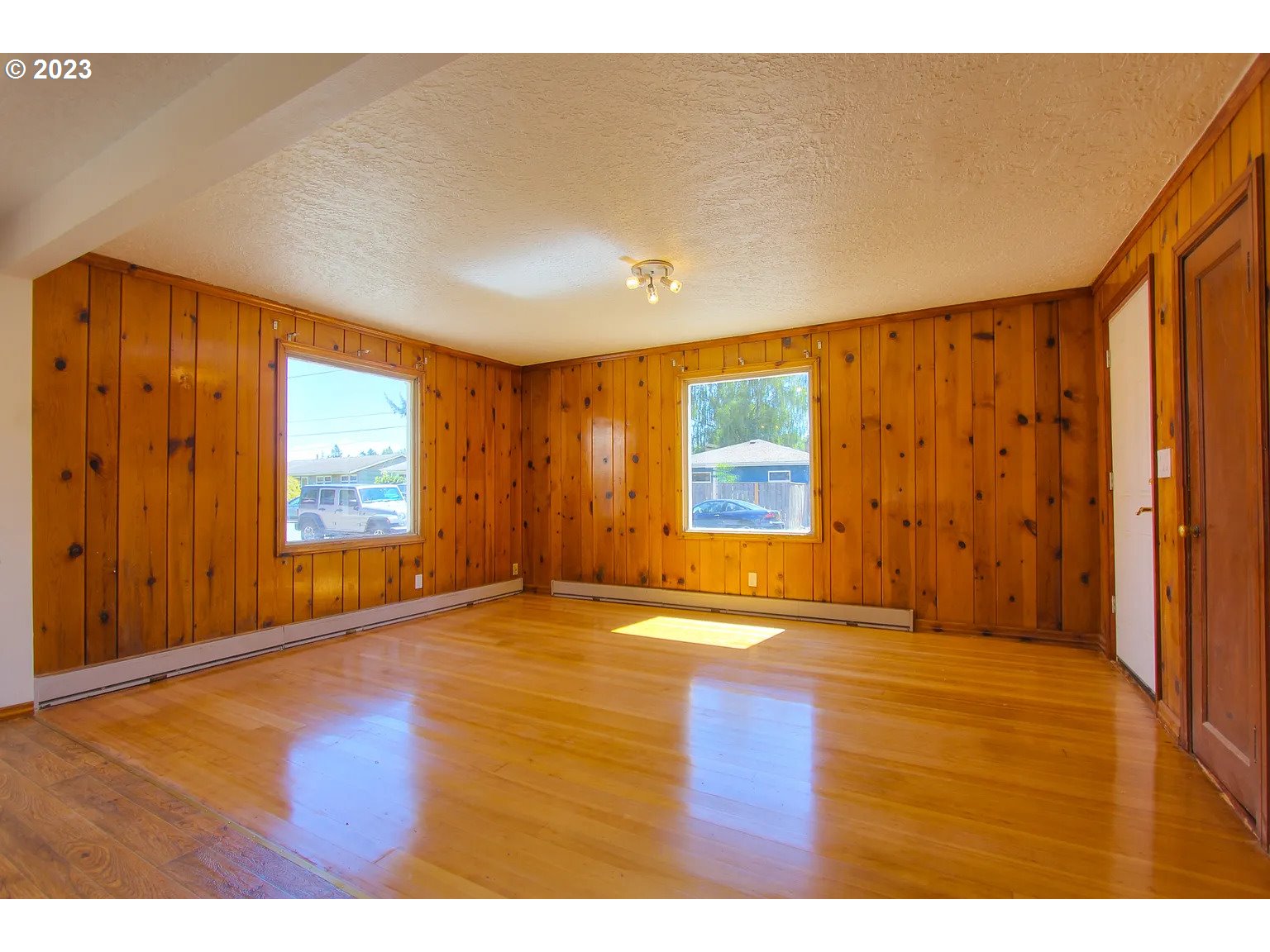 711 Southeast 5th Street Gresham, OR 97080 - Photo 4 of 25 a view of an empty room with wooden floor and a window