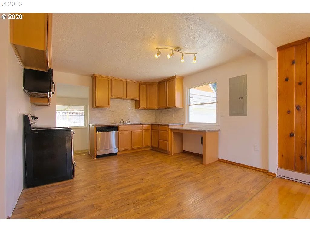 711 Southeast 5th Street Gresham, OR 97080 - Photo 5 of 25 a kitchen with a refrigerator and a sink