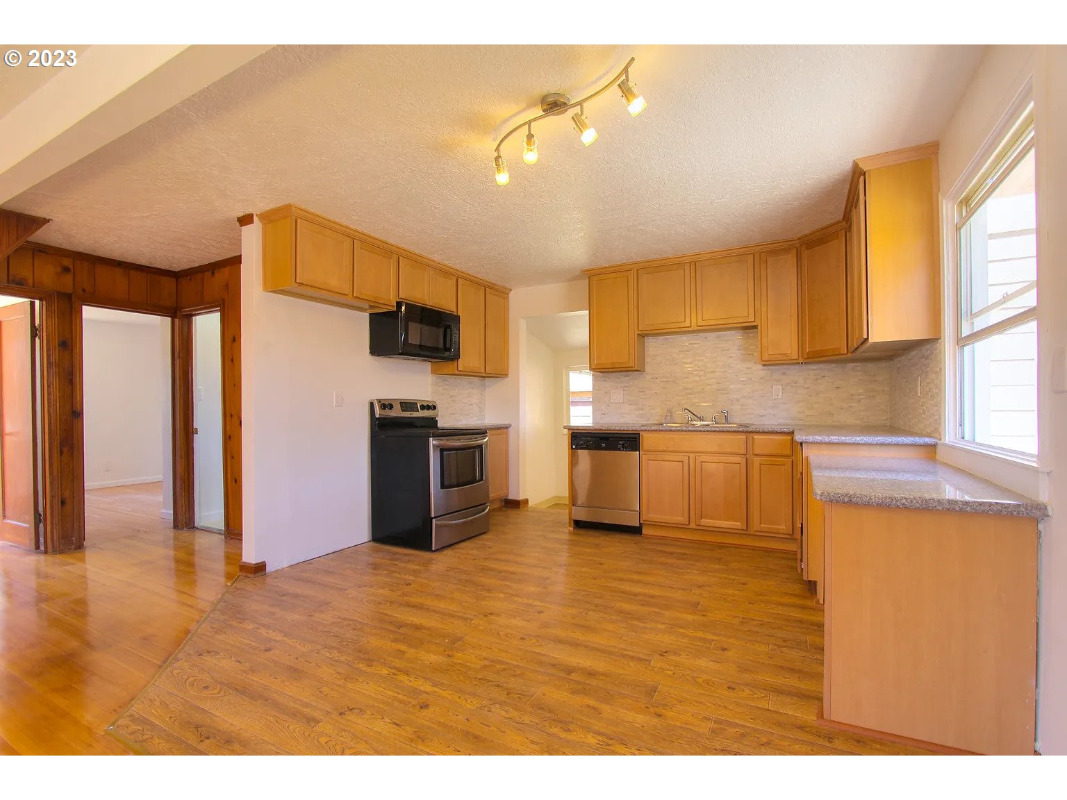 711 Southeast 5th Street Gresham, OR 97080 - Photo 6 of 25 a kitchen with stainless steel appliances kitchen island granite countertop a stove and a sink