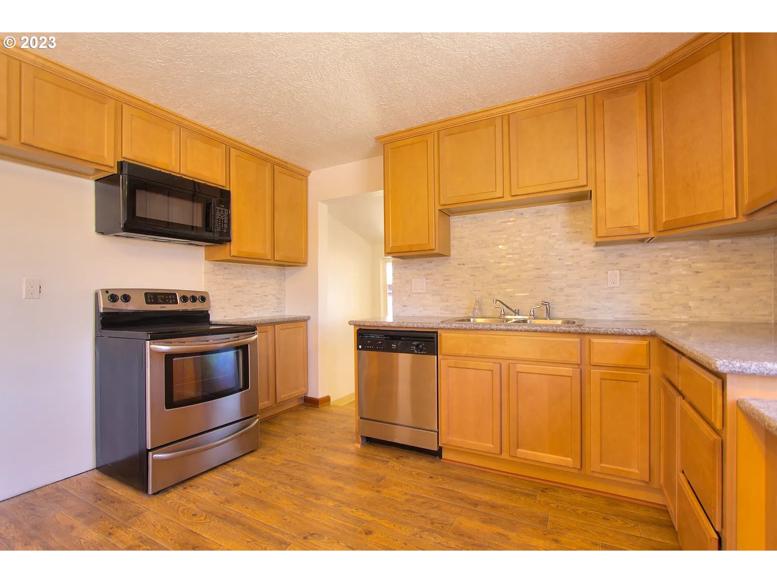711 Southeast 5th Street Gresham, OR 97080 - Photo 7 of 25 a kitchen with stainless steel appliances granite countertop a stove a sink and a microwave