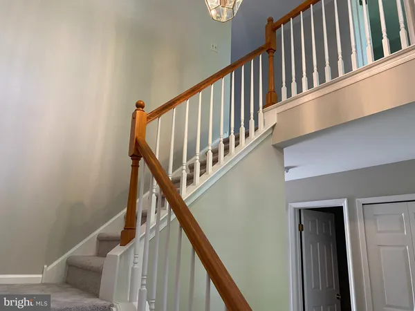 a view of staircase with railing and lots of frames on wall