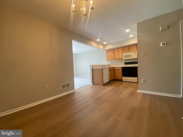 a view of a big room with wooden floor and windows