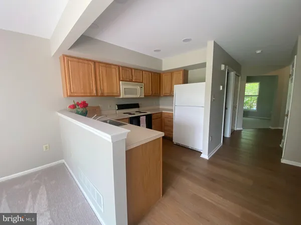 a kitchen with a refrigerator a stove top oven a sink and a window