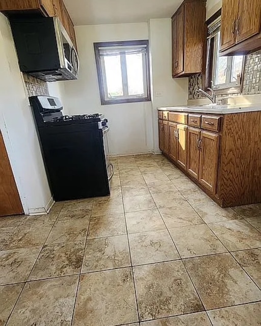 37 Choate Road Park Forest, IL 60466 - Photo 9 of 17 a kitchen with stainless steel appliances a sink a stove a microwave a counter top space and cabinets