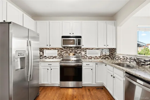 a kitchen with stainless steel appliances cabinets a sink and a refrigerator