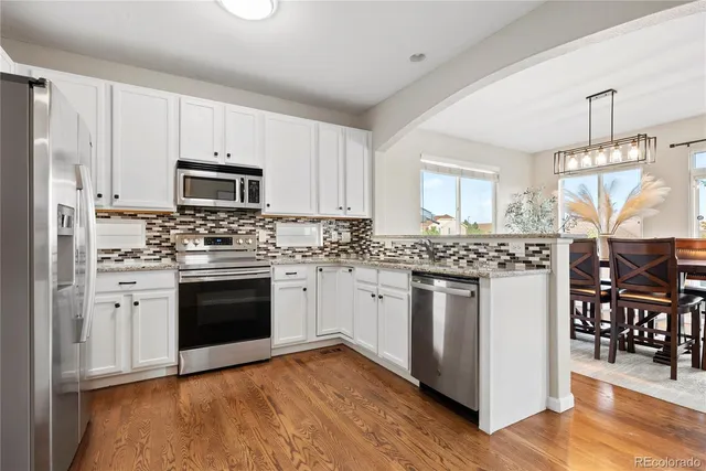 a kitchen with stainless steel appliances granite countertop a stove a sink and a refrigerator