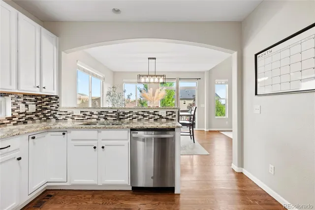 a kitchen with stainless steel appliances granite countertop a stove and a white cabinets