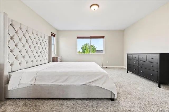 a spacious bedroom with a bed and a window