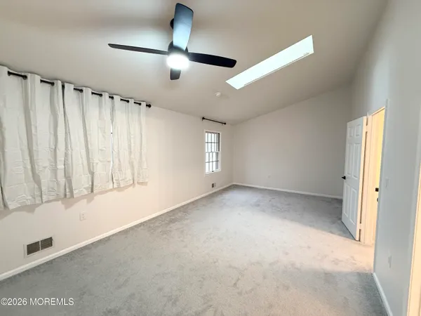 an empty room with windows and cabinet