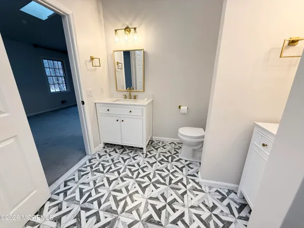 a bathroom with a toilet sink and mirror