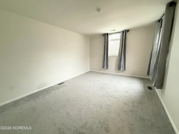 an empty room with windows and closet