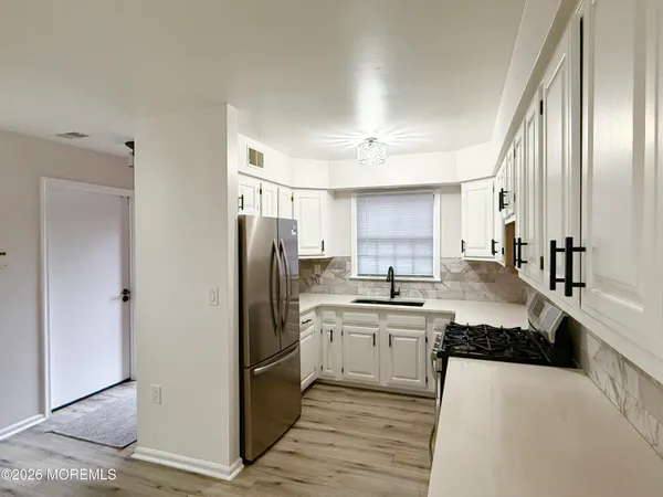 a large kitchen with cabinets and stainless steel appliances