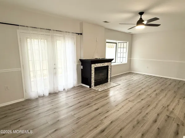 a living room with wooden floor and a fireplace