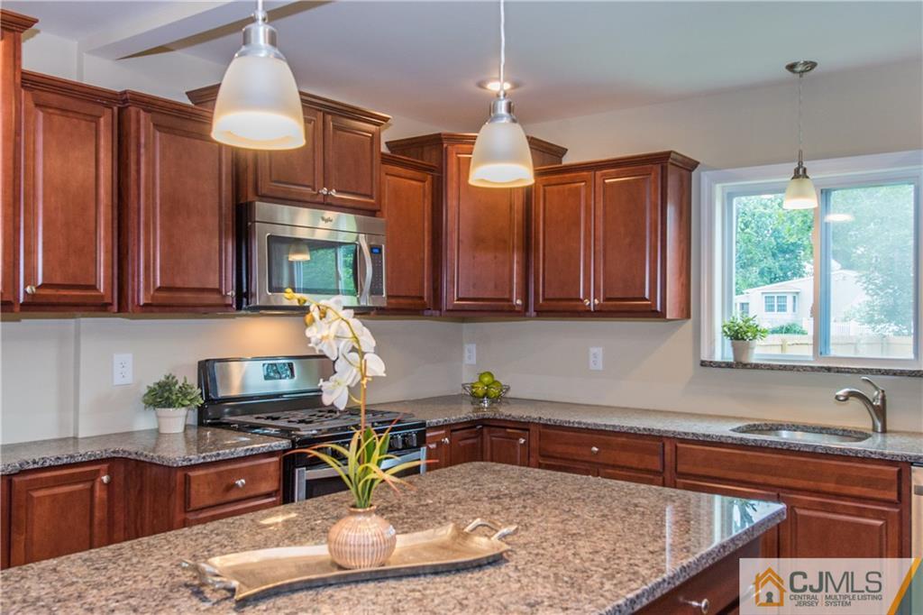 60 Morgan Drive Edison, NJ 08817 - Photo 9 of 20 a kitchen with stainless steel appliances granite countertop a sink a stove and a wooden cabinets