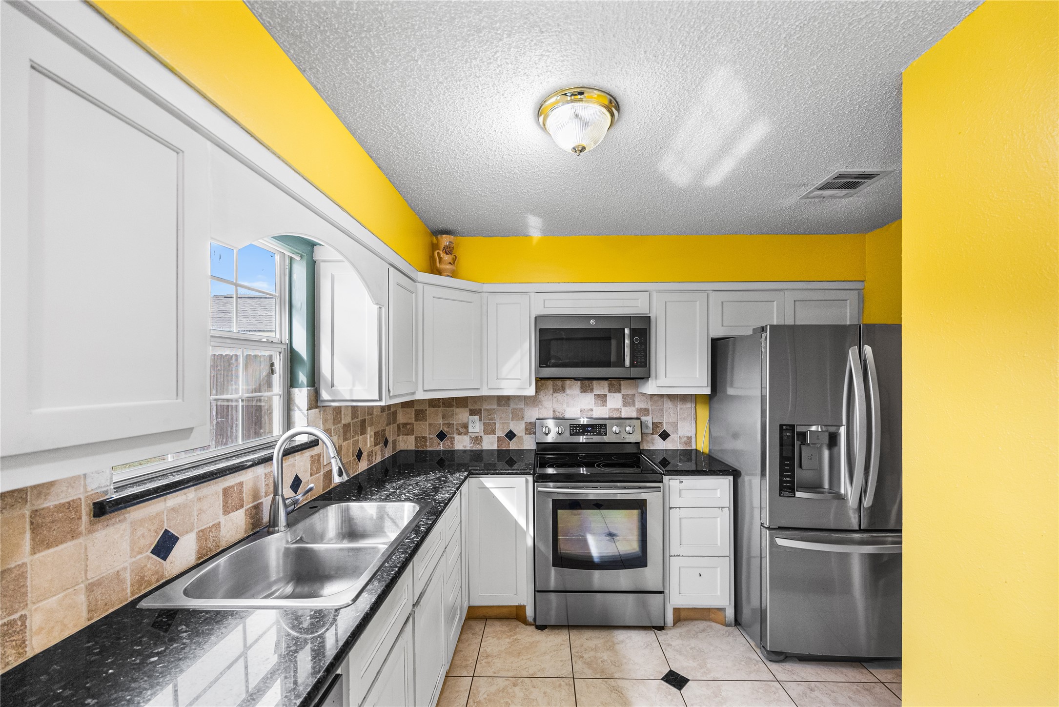 7211 Sandswept Lane Houston, TX 77086 - Photo 20 of 29 a kitchen with stainless steel appliances granite countertop a sink and a refrigerator