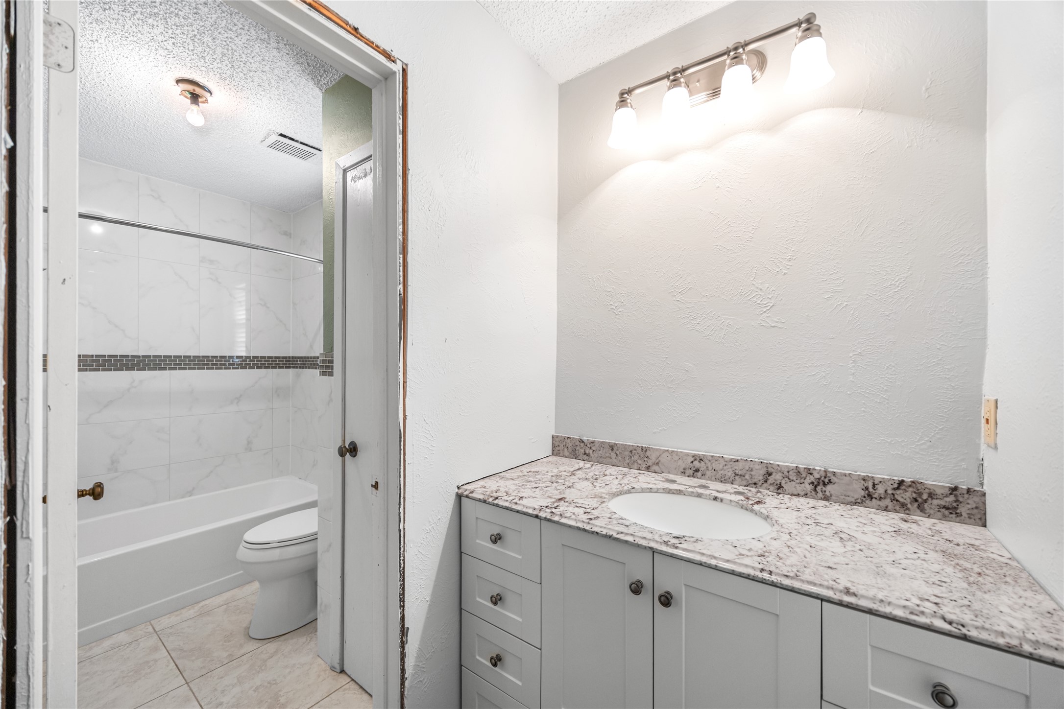 7211 Sandswept Lane Houston, TX 77086 - Photo 5 of 29 a bathroom with a granite countertop sink toilet and shower
