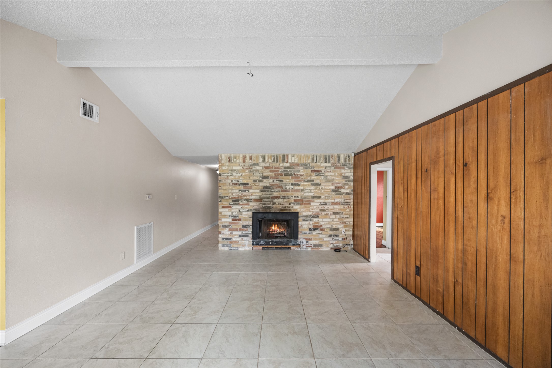 7211 Sandswept Lane Houston, TX 77086 - Photo 9 of 29 an empty room with fireplace chandelier and windows