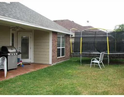 a backyard of a house with table and chairs