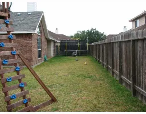 a view of a backyard with basketball court