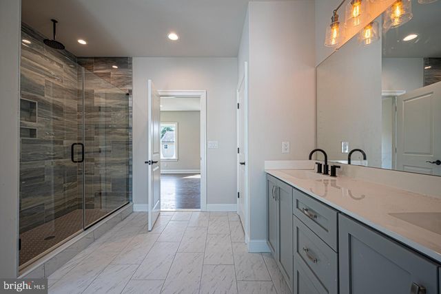a bathroom with a shower sink and mirror