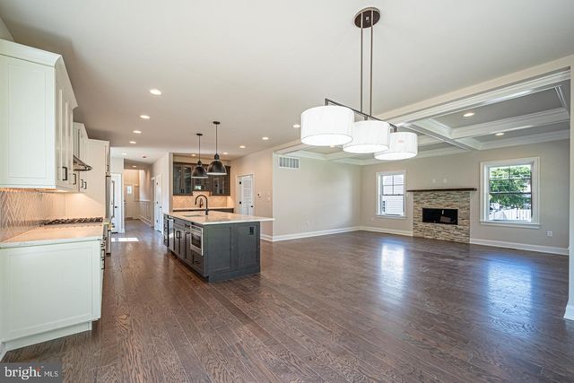 a view of a kitchen center island wooden floor and a fireplace
